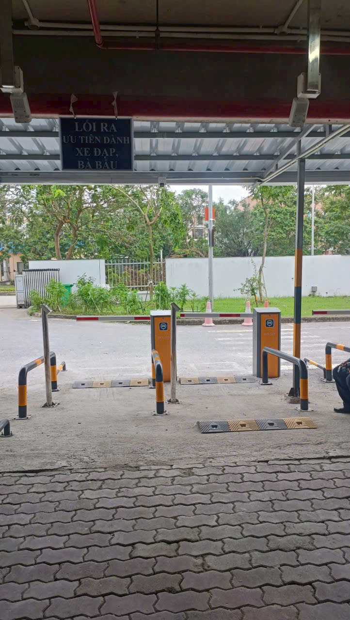 Lối ra bãi giữ xe đạp với thanh chắn tự động và biển ưu tiên cho phụ nữ mang thai